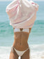 Person wearing a pink hoodie with 'KATE' text and white bikini at the beach.