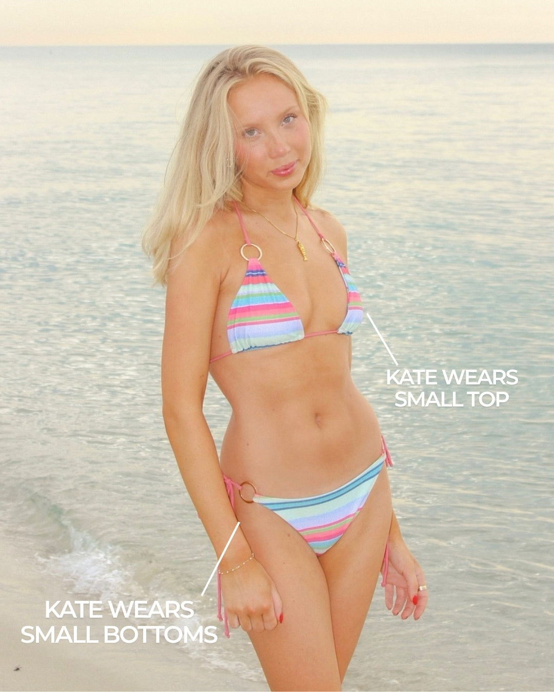 Woman in a colorful striped bikini standing on a beach.