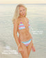 Woman in a colorful striped bikini standing on a beach.